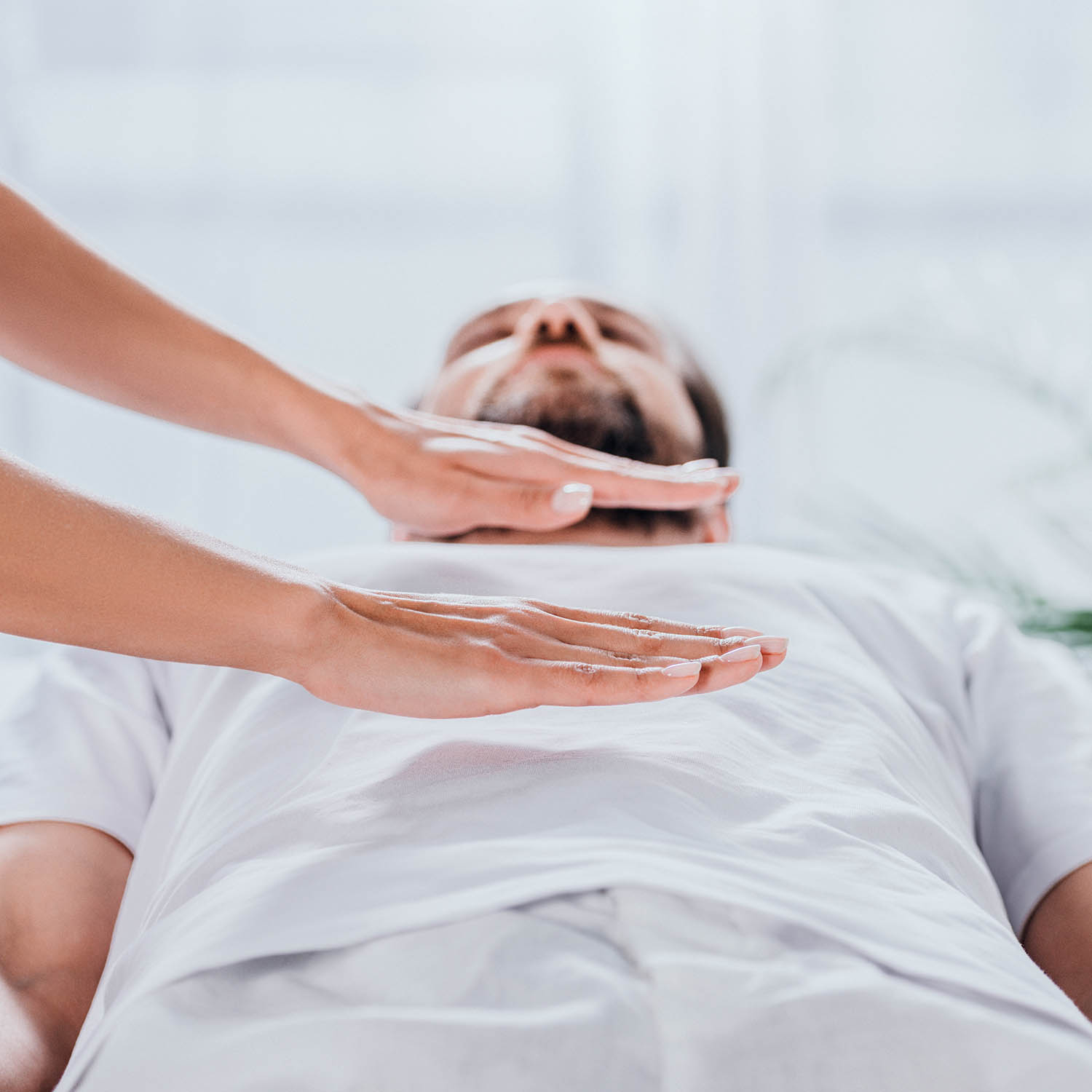 cropped shot of bearded man receiving reiki healing session above stomach